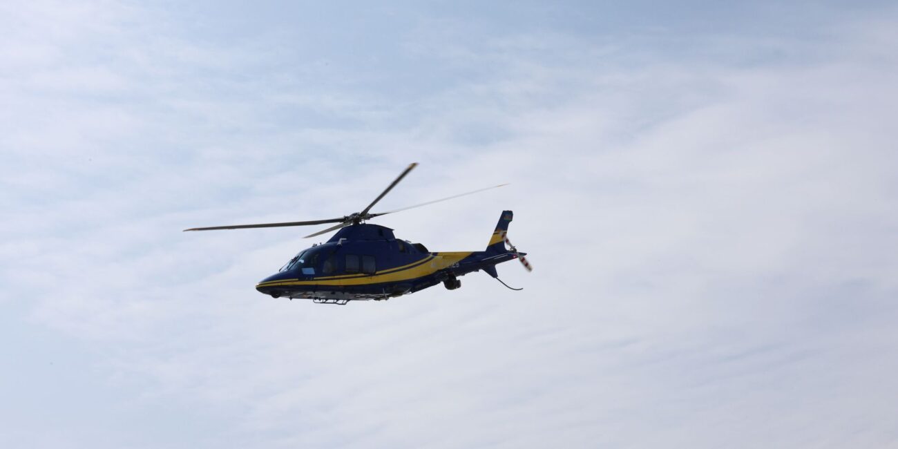blue and yellow helicopter in flight against sky